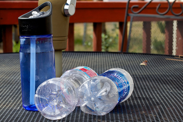Reusable bottle next to two disposable bottles. Photo by Alan Levine.