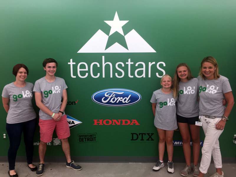 GoKid team + Founder's children standing in front of the Techstars logo at Techstars Mobility Detroit