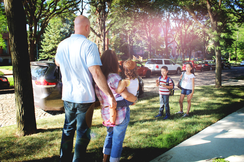 Family waving goodbye to kids