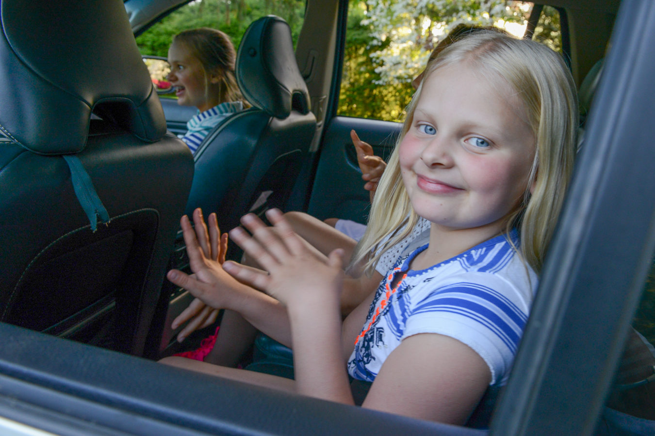 children sitting in back of car