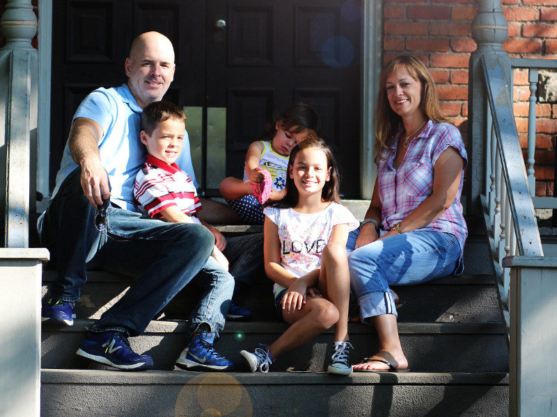 Family sitting on steps of home