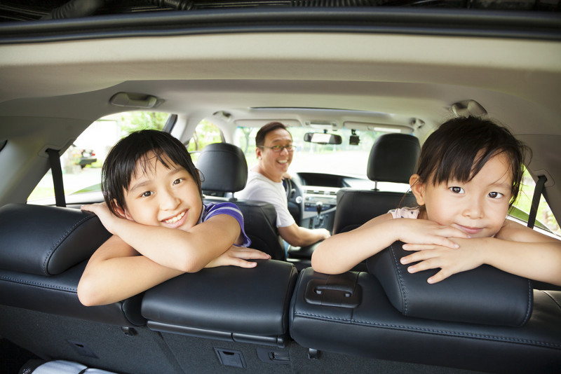 girls in back seat of car, looking back at camera