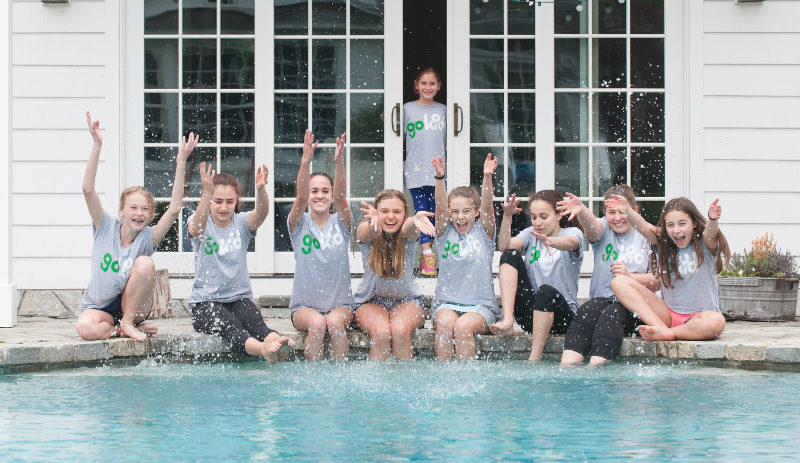 girls in Gokid t-shirts sitting by poolside