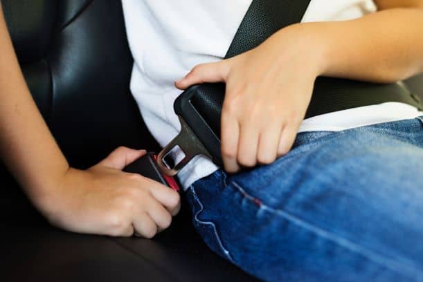 child buckling up in a car