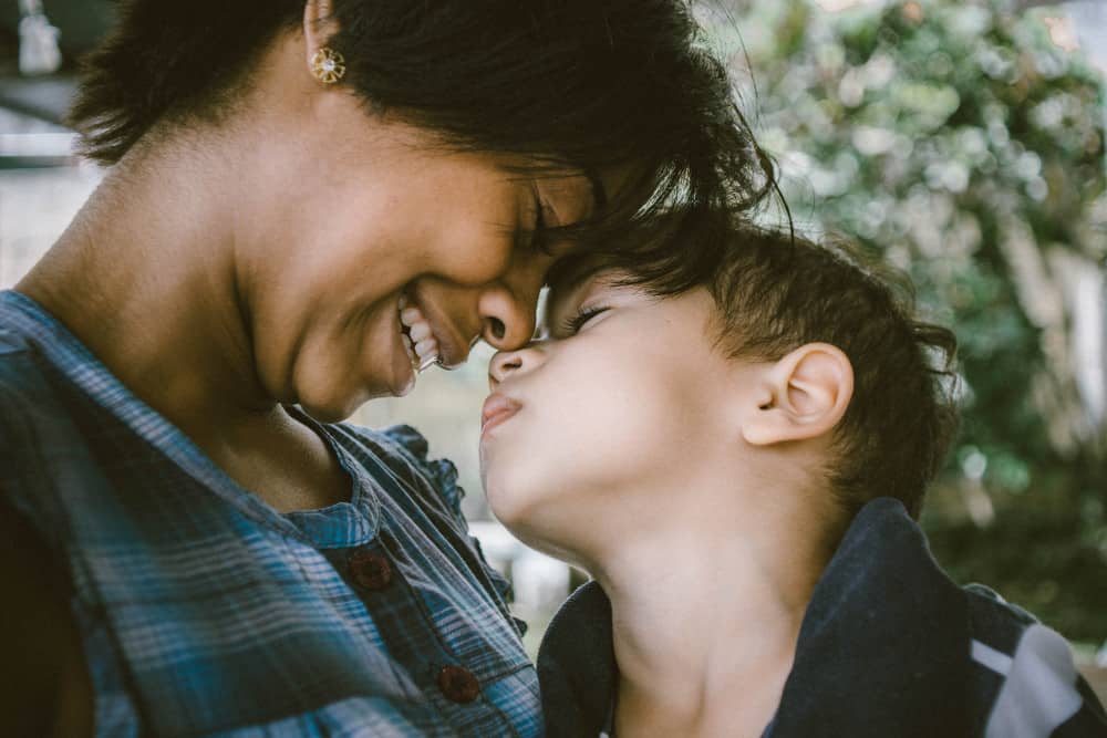 Photo of mom and child with heads together by Bruno Nascimento on Unsplash