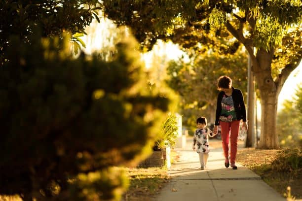 Mom and child walking on sidewalk